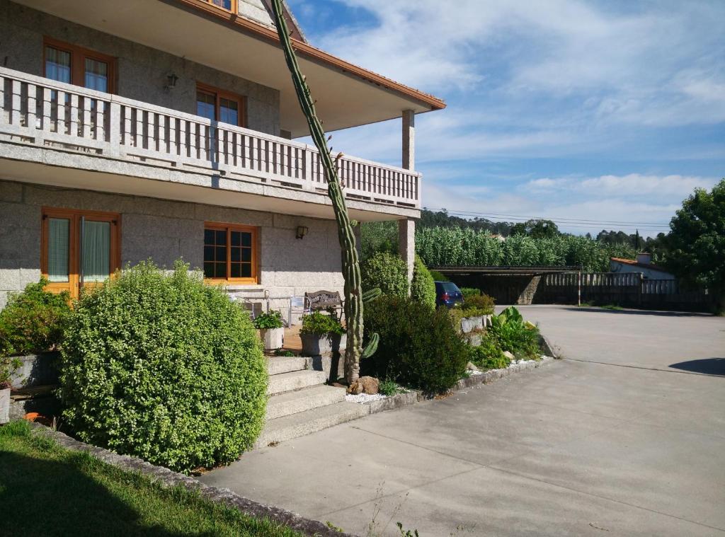 uma casa com um alpendre e escadas em frente em Hostal - Restaurante Casa Cuña em Tebra