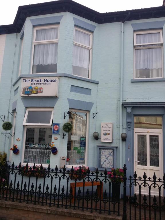 a blue house with a fence in front of it at The Beach House in Great Yarmouth