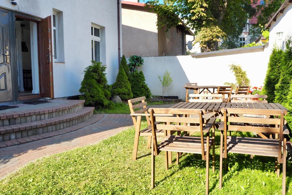 una mesa de madera y sillas en un patio en VIU Garden & Sun, en Sopot