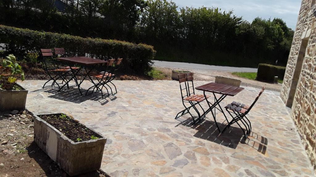 un grupo de mesas y sillas en un patio en Les Ecuries, en Saint-Maurice-en-Cotentin