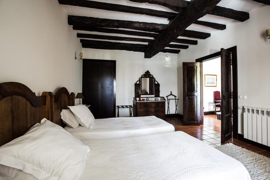 een slaapkamer met 2 bedden en een houten plafond bij Solar do Morgado Oliveira in Macedo de Cavaleiros