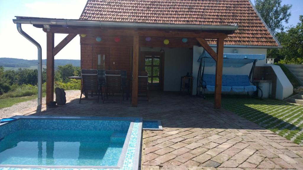 a pavilion with a swimming pool in front of a house at Pécsely apartman in Pécsely