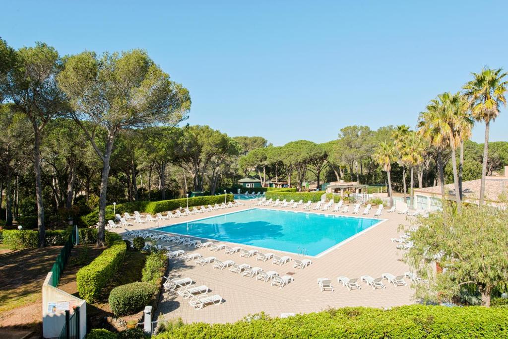 uma imagem de uma piscina com espreguiçadeiras em Residence Saint-Raphael Valescure - maeva Home em Saint-Raphaël