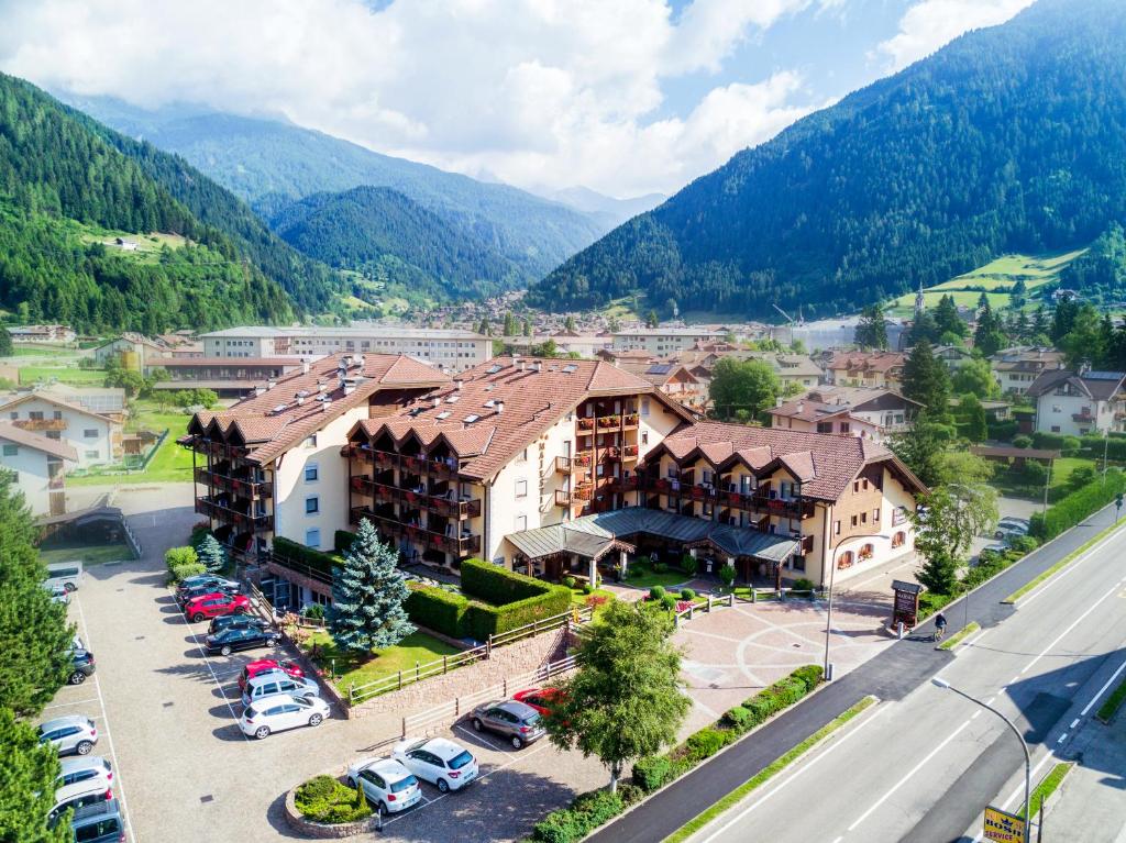 une vue aérienne sur une ville avec des montagnes en arrière-plan dans l'établissement Aparthotel Majestic, à Predazzo