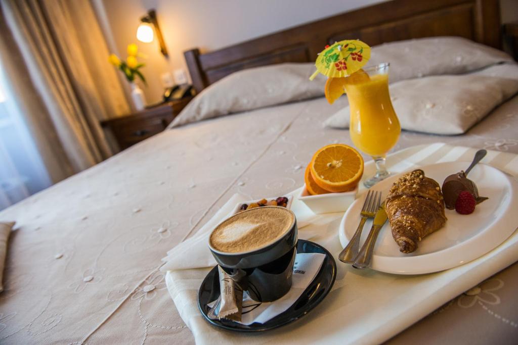 ein Tablett mit Essen und einem Getränk auf dem Bett in der Unterkunft Complex Casa Lux in Botoşani