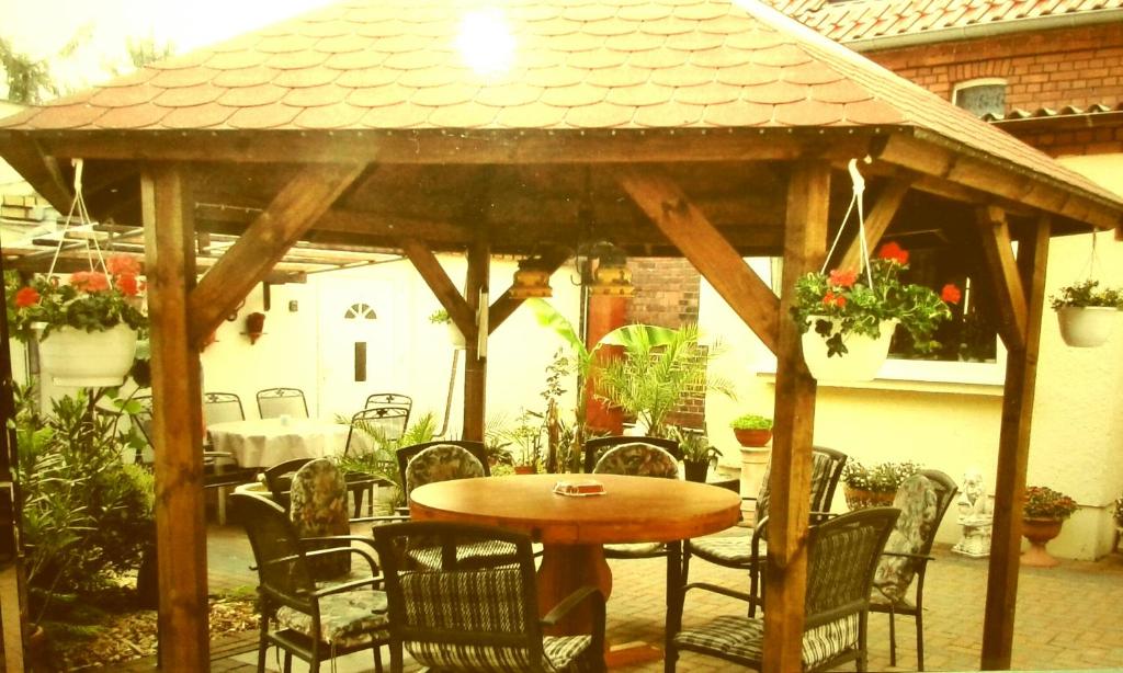 a wooden gazebo with a table and chairs at Zum Holzwurm in Mühlanger