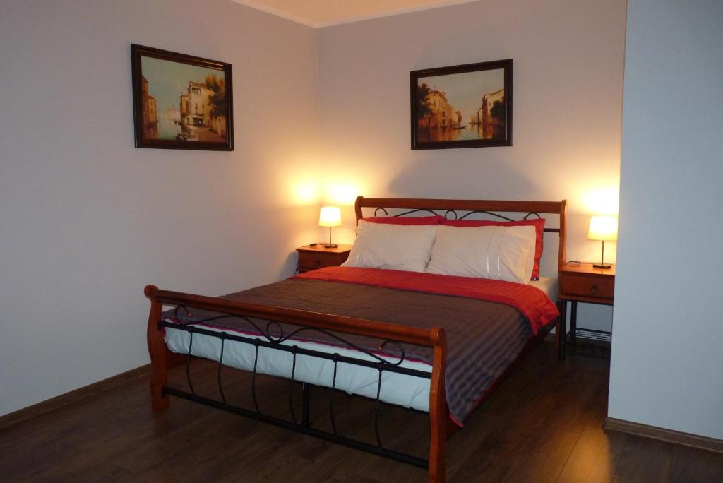 ザモシチにあるApartament Młyńskaのベッドルーム1室(ベッド1台、ランプ2つ、テーブル2台付)
