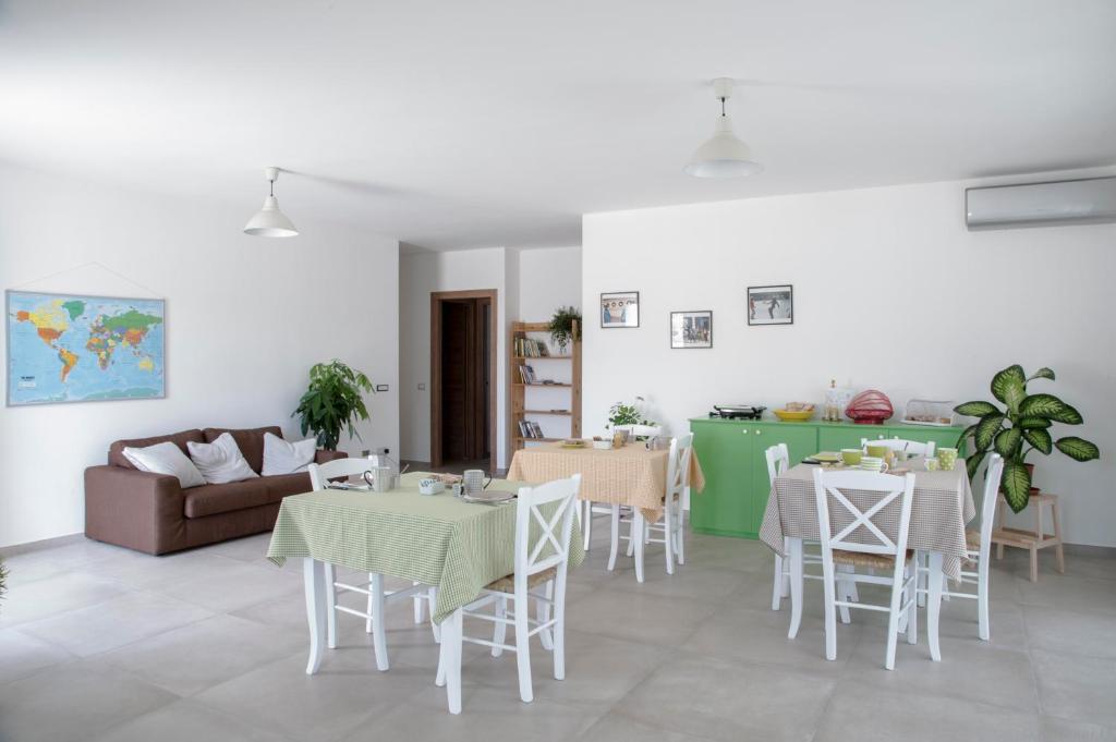 salon z dwoma stołami i kanapą w obiekcie B&B Agata e gli altri w mieście Tortolì