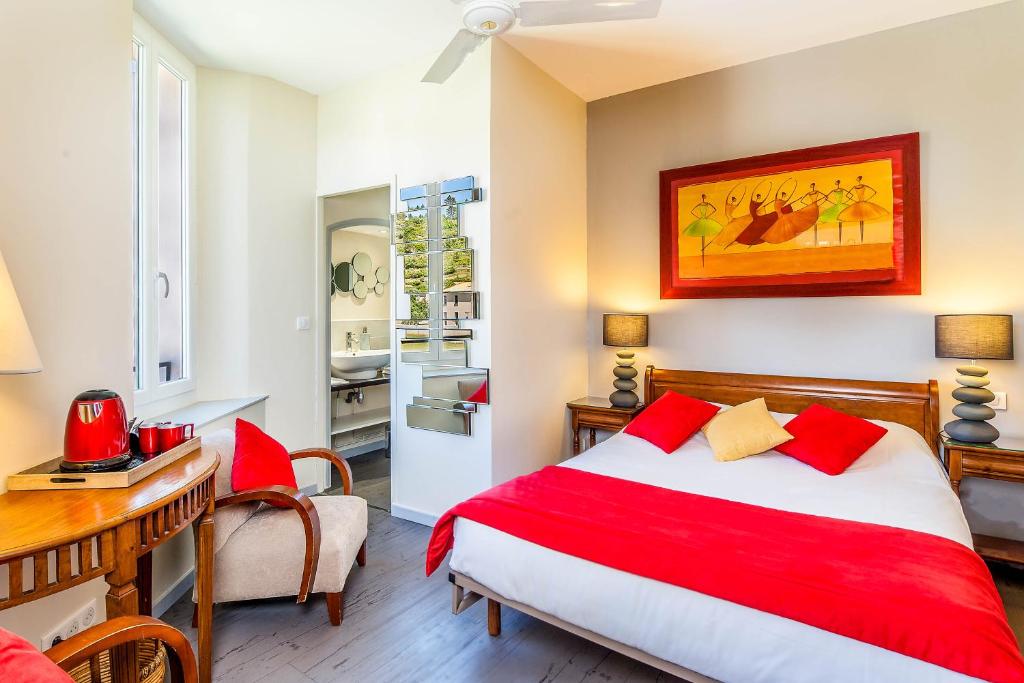 a bedroom with a bed and a table and a desk at Logis Hôtel Restaurant des Corbières in Lagrasse