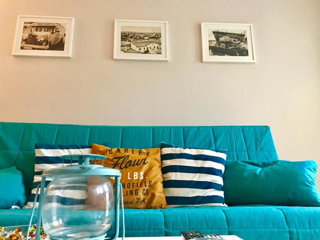 niebieska kanapa z poduszkami i waza na stole w obiekcie Apartament Redłowo w mieście Gdynia