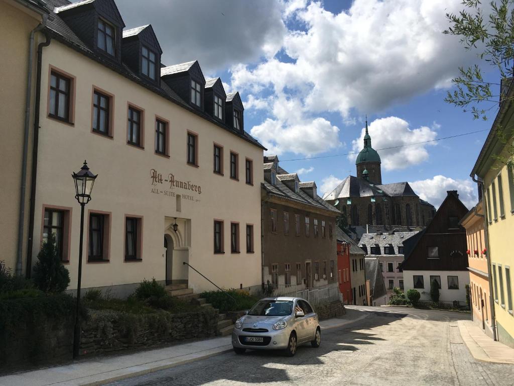 une petite voiture garée devant un bâtiment dans l'établissement Hotel Alt Annaberg, à Annaberg-Buchholz