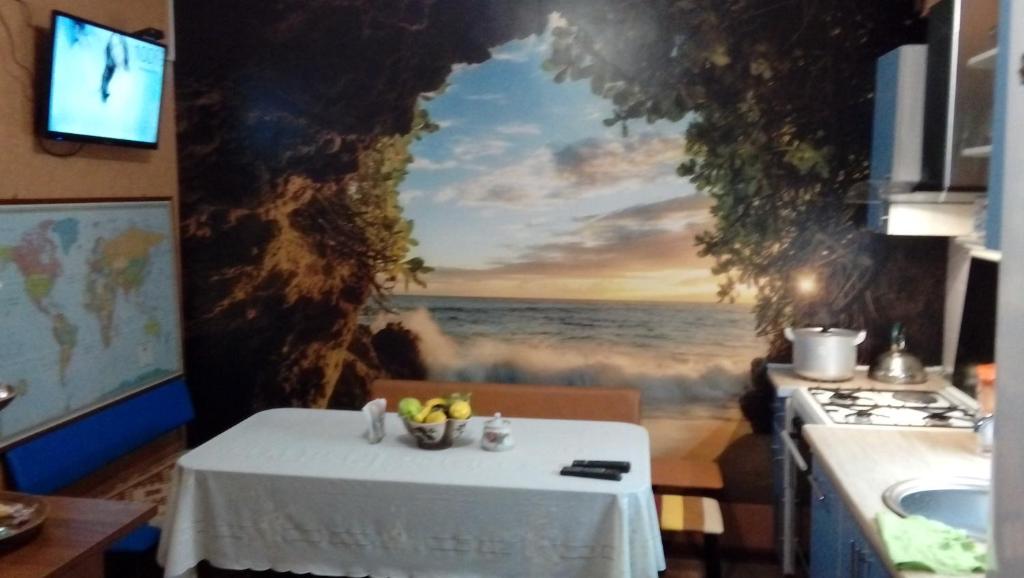 a table in a kitchen with a painting of the ocean at Hostel Viator in Almaty