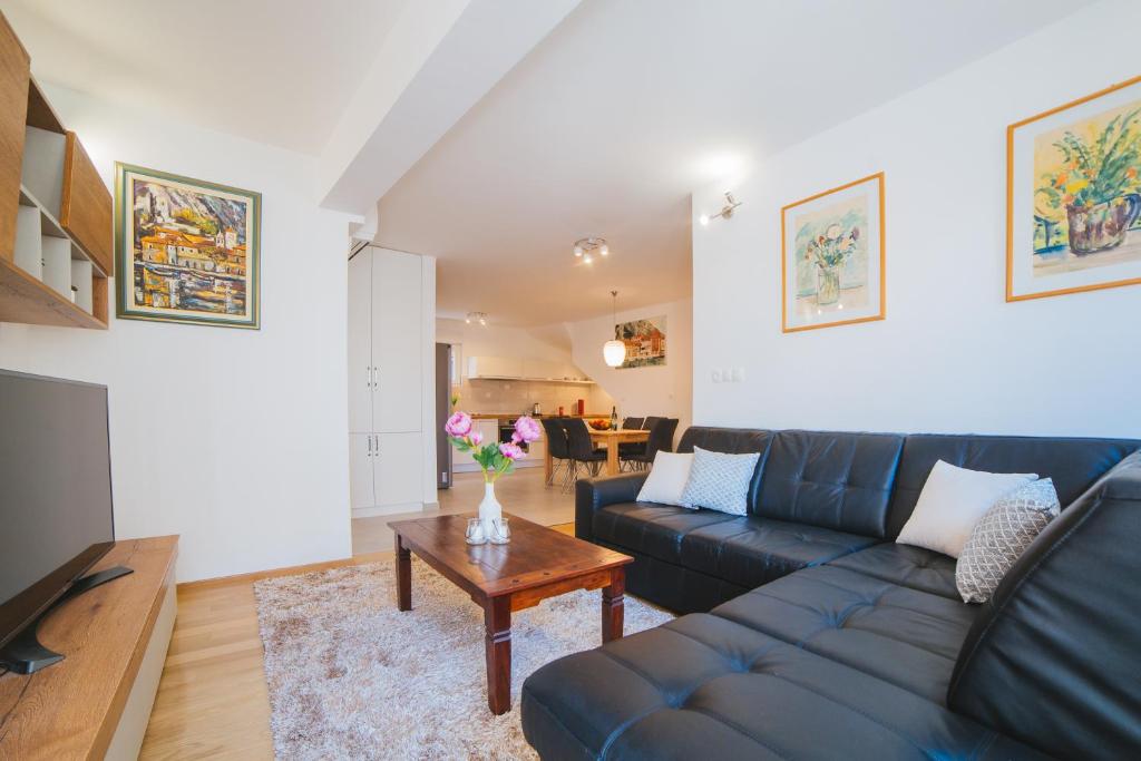 a living room with a blue couch and a table at City Center LUX Apartment "TONCI" in Omiš
