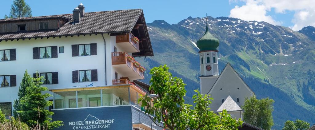 a building with a church and a mountain at Hotel Bergerhof in Bartholomäberg