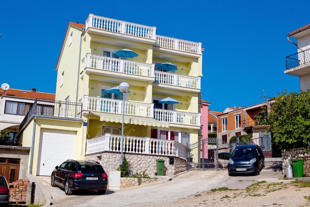 two cars parked in front of a building with balconies at Apartment Crikvenica, Vinodol 3 in Crikvenica