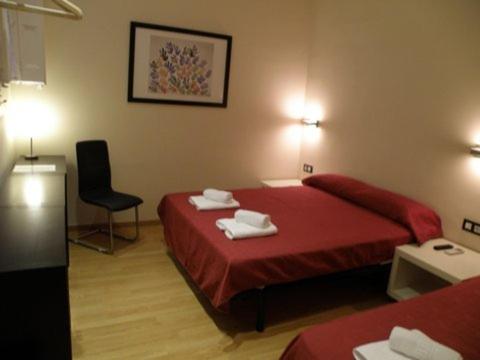 a hotel room with a red bed and a chair at Center Gran Via in Barcelona