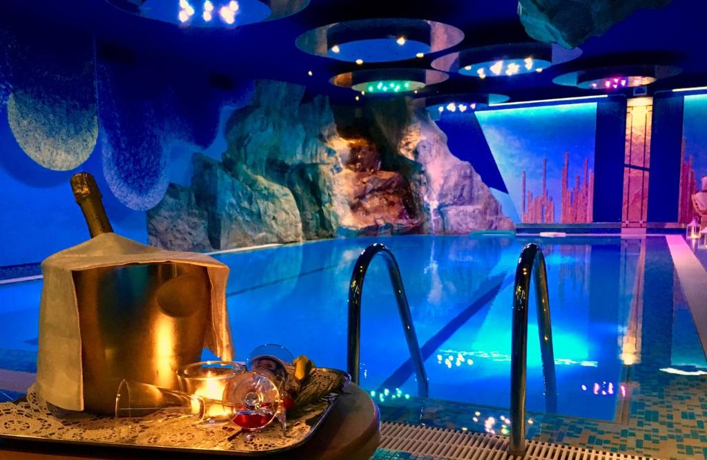 a sink with a bottle of wine next to an aquarium at Hotel Mirabello - Slow Hotel Benessere in Fiera di Primiero