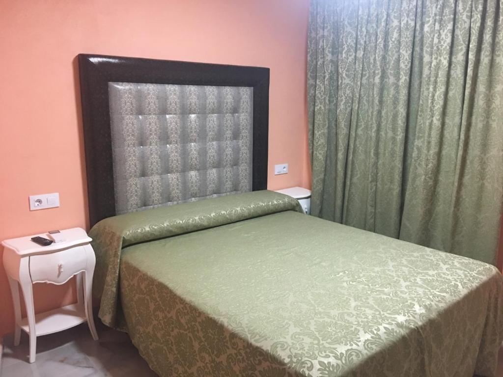 a bedroom with a bed with a green bedspread at Hotel Just Style El Mañico in Peñíscola