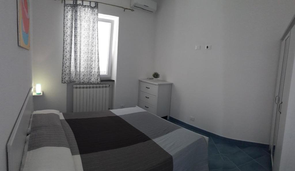 een kleine slaapkamer met een bed en een raam bij Citara mare in Ischia