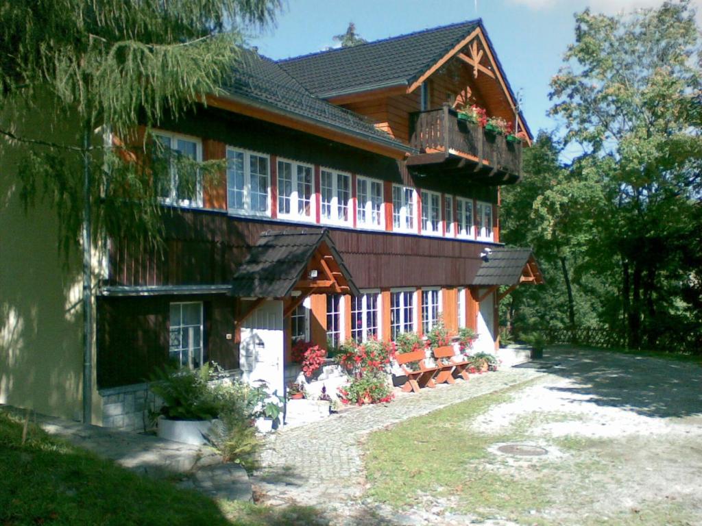 a large wooden house with flowers on the porch at Nasz Domek in Karpacz