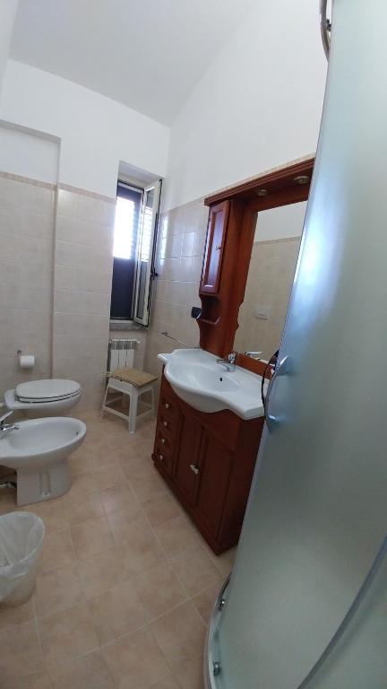 a bathroom with two toilets and a sink and a mirror at Bruno B&B in Cropani