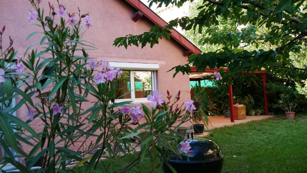 a pink house with purple flowers in the yard at Villa Seignemartin in Lyon