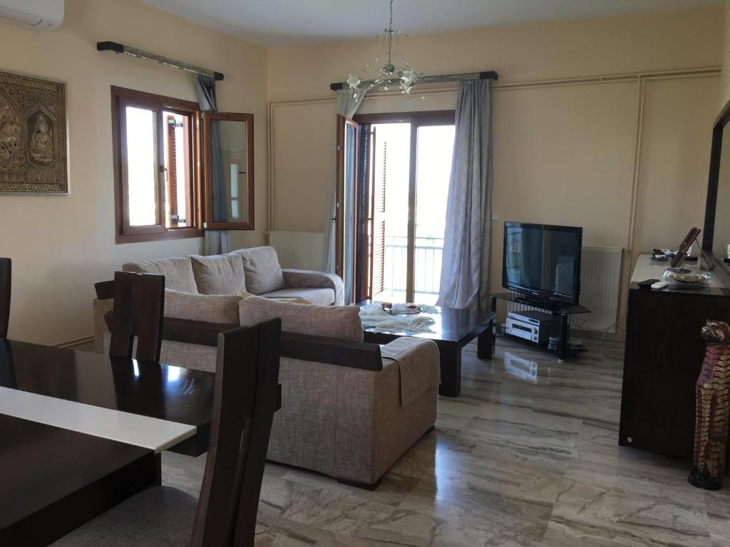 a living room with a couch and a tv at Family Cozy House Nafplio in Nafplio