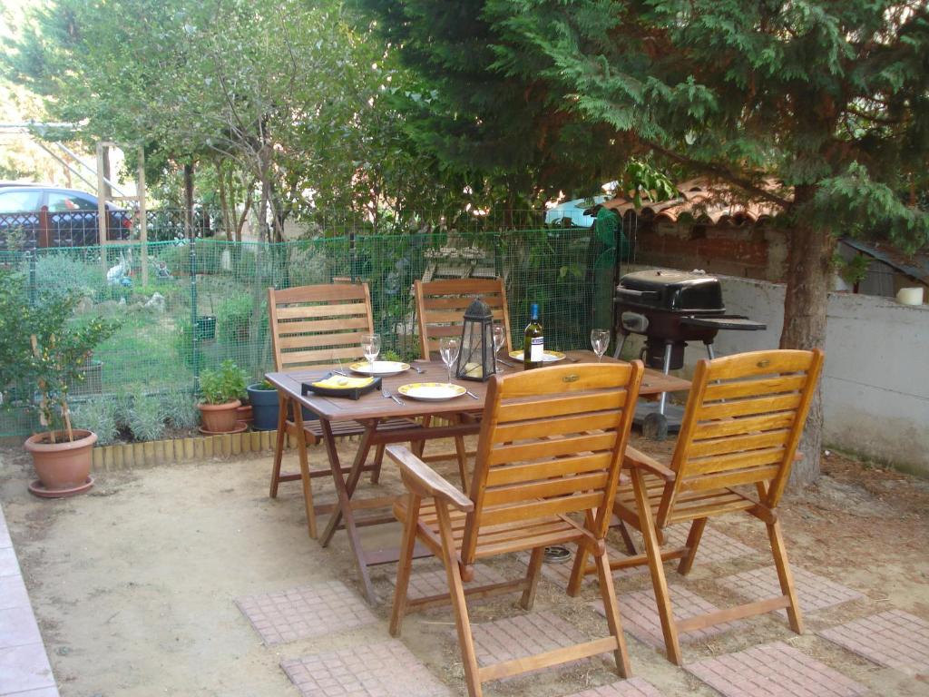 uma mesa de madeira com 4 cadeiras e um grelhador em Seaside Apartment em Tessalônica