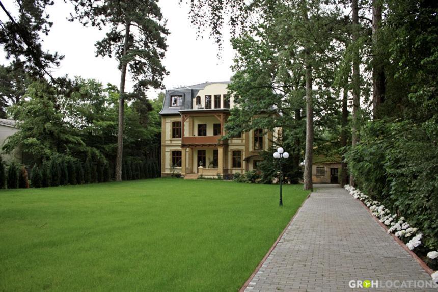 ein großes Haus mit grünem Rasen davor in der Unterkunft Residenz Villa Kult in Berlin