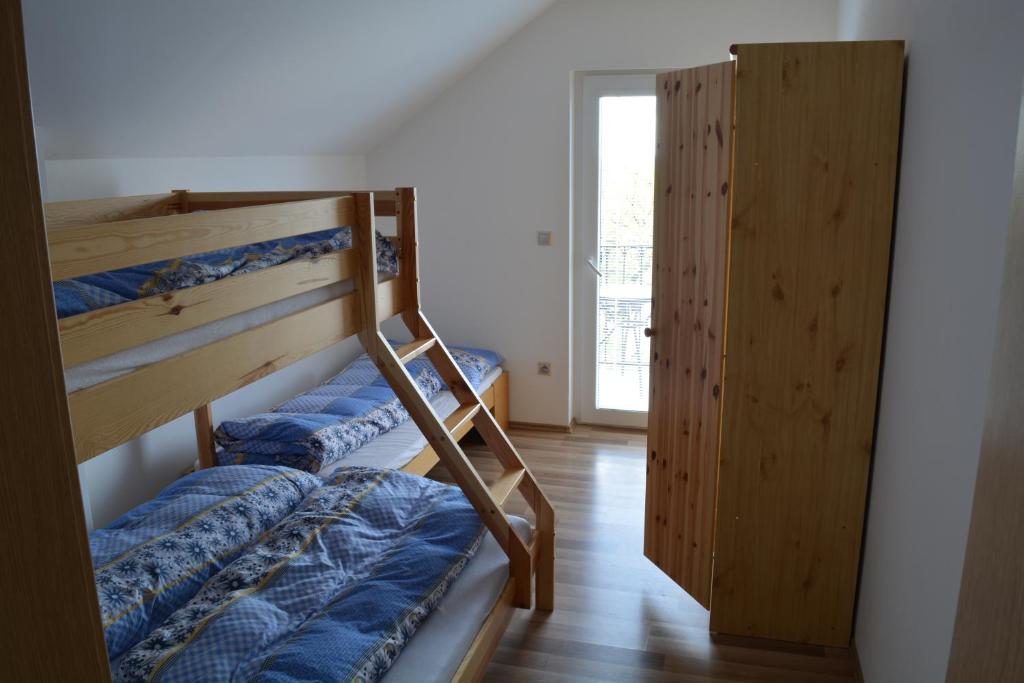 2 Etagenbetten in einem Zimmer mit Fenster in der Unterkunft Ubytovani U Ruzenky in Velké Bílovice