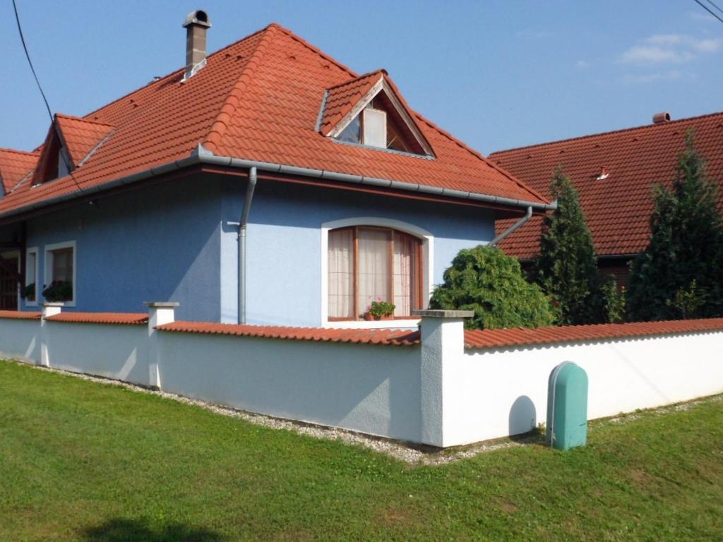 uma casa com um telhado vermelho e uma parede branca em Apartment in Balatonbereny/Balaton 18043 em Balatonberény