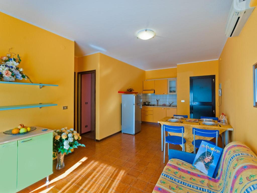 una cucina con pareti gialle, tavolo e sedie di Apartments in Bibione 24416C a Bibione