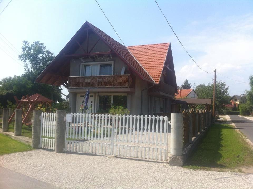 a house with a white fence in front of it at Apartment Balatonkeresztur/Balaton 19286 in Balatonkeresztúr