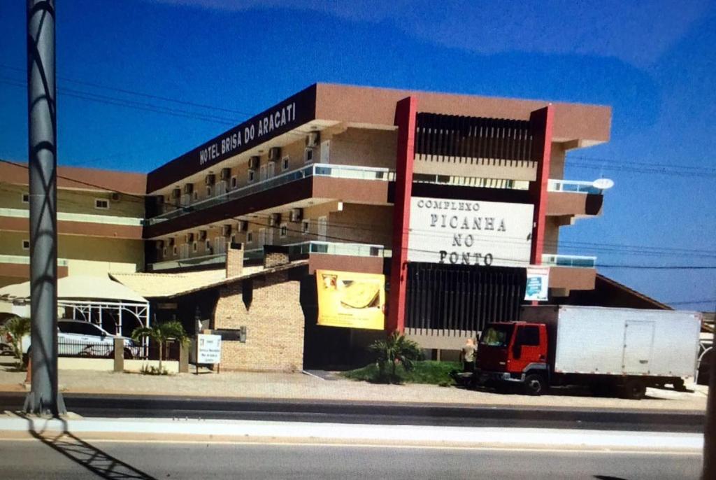 a building with a truck parked in front of it at Hotel Brisa do Aracati in Aracati