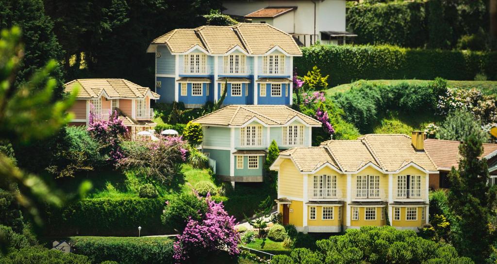 a group of houses in a yard with flowers at Pousada Vila das Cores in Campos do Jordão