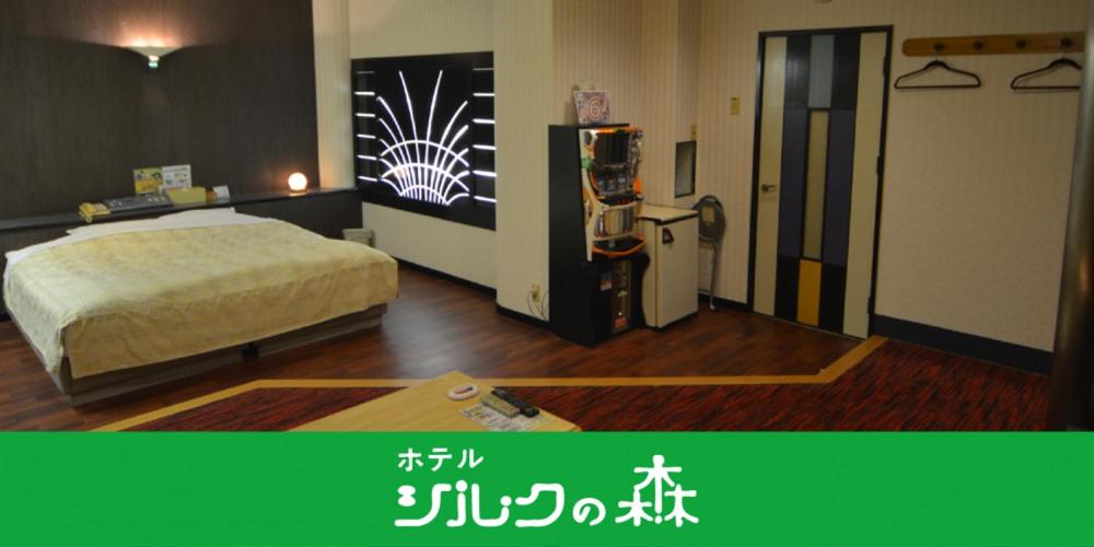 a hotel room with a bed and a machine in it at Hotel Silk no Mori (Adult Only) in Tosu