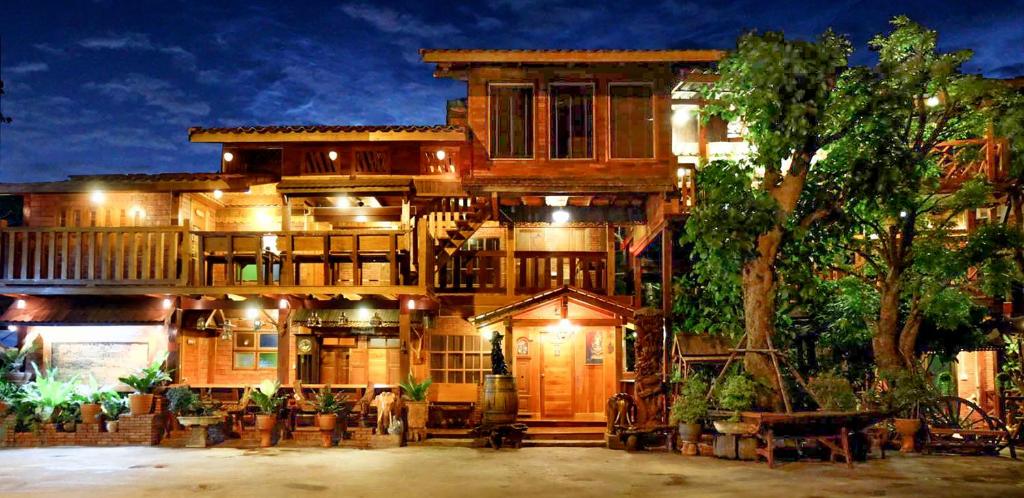 a large wooden house with a tree at Klong Suan Plue Resort in Phra Nakhon Si Ayutthaya