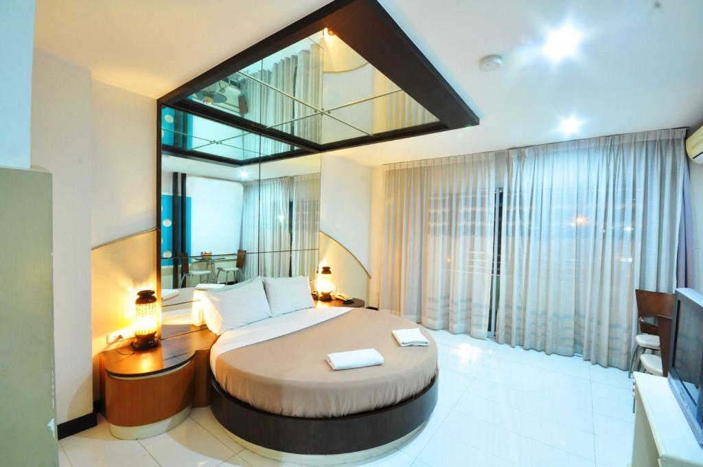 a bedroom with a large bed and a large window at The Great Hotel Hatyai in Hat Yai