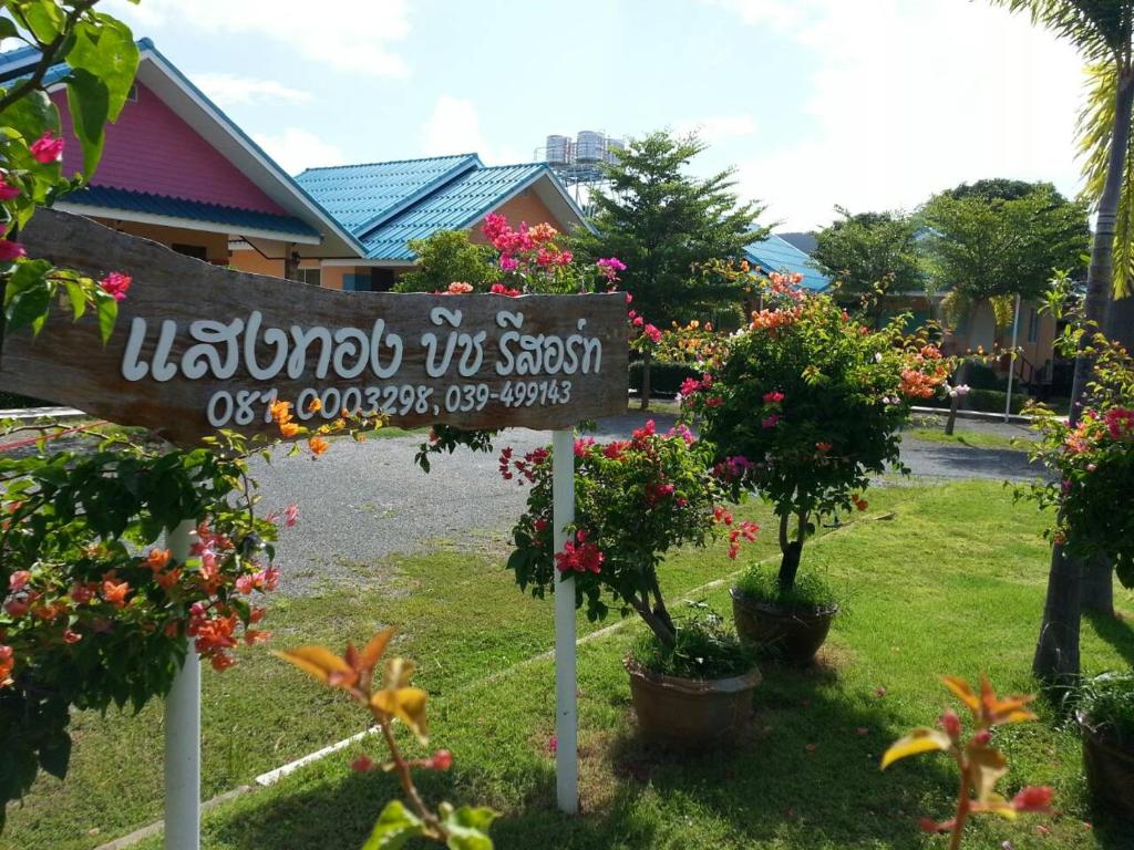 um sinal em frente a um quintal com flores em Sangtong Beach Resort em Laem Sing