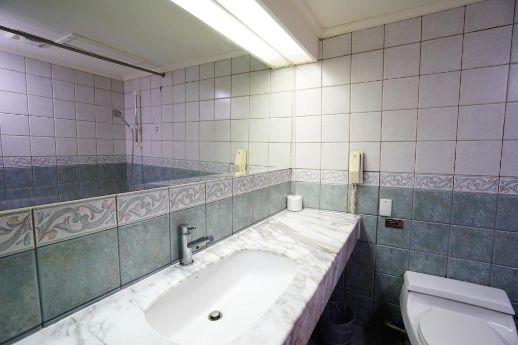 a bathroom with a sink and a toilet at Cambridge Tainan Hotel in Tainan