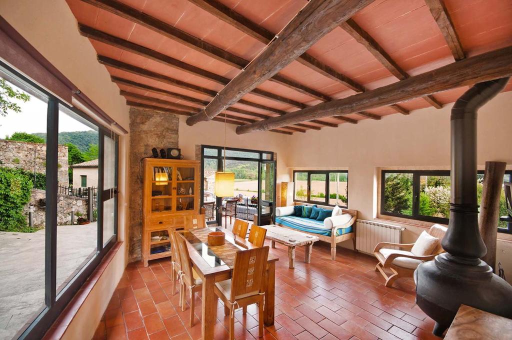 ein Wohnzimmer mit einem Tisch, Stühlen und Fenstern in der Unterkunft Villa Amedeo in Rosia