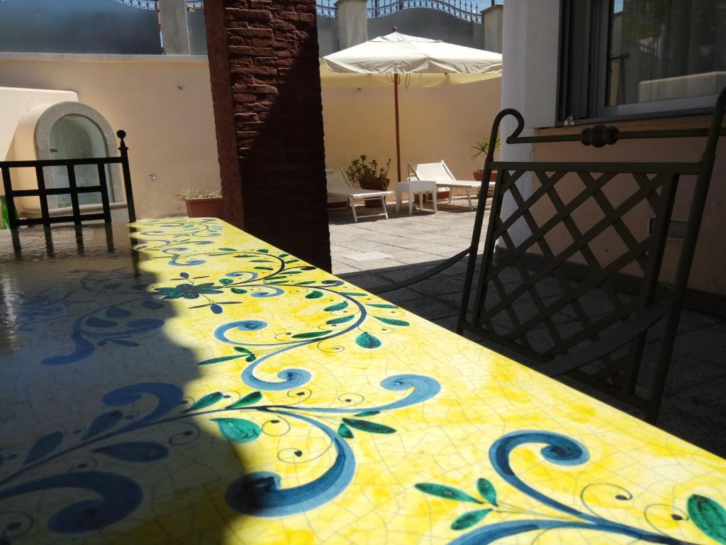 un tavolo con un disegno giallo e blu sopra di Villa Pithecusa a Ischia