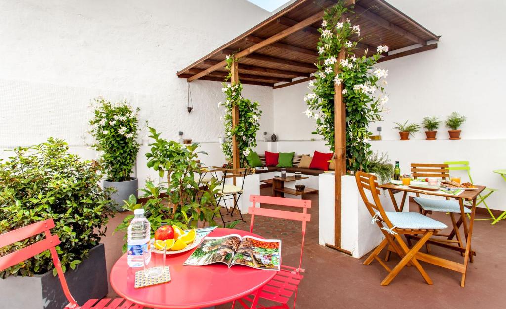 a patio with a red table and chairs and plants at City Garden Bed and Breakfast in Valencia