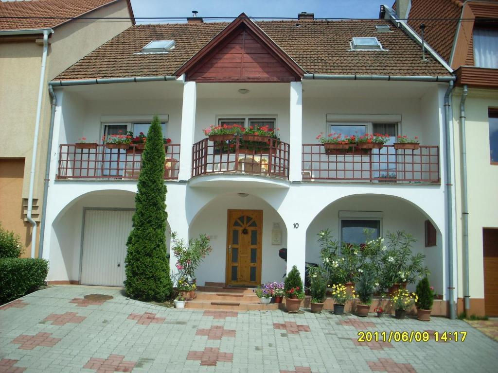 a white house with flower boxes on the balconies at Holiday Vendégház in Eger