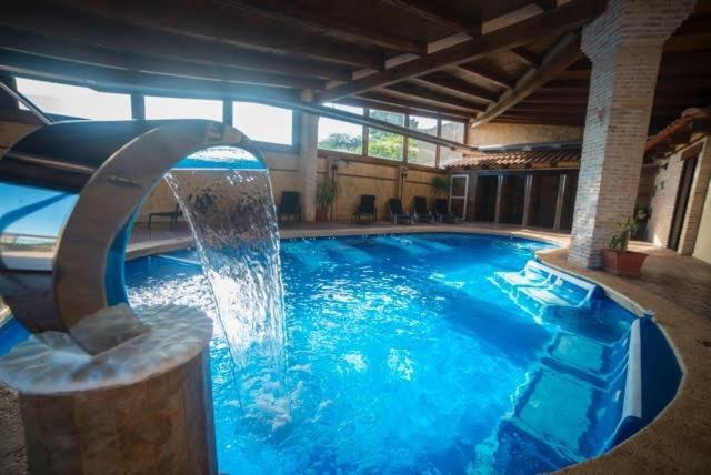 a large swimming pool with a water fountain at Hostal Rural & Spa Las Vistas in Pastrana