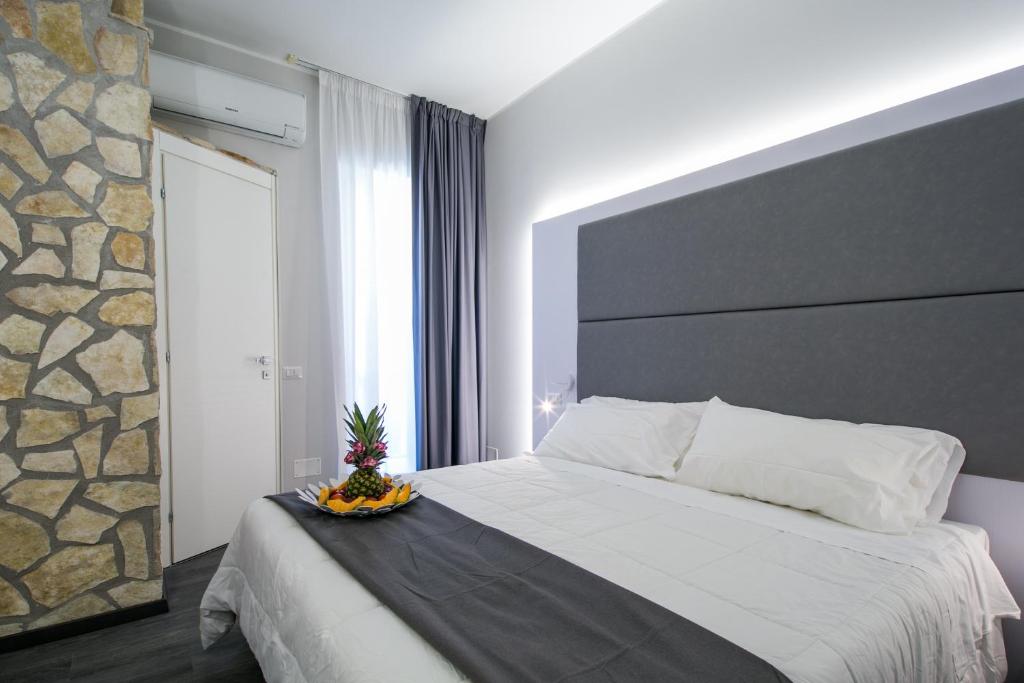 1 dormitorio con 1 cama grande y pared de piedra en Hotel La Torraccia, en Tarquinia