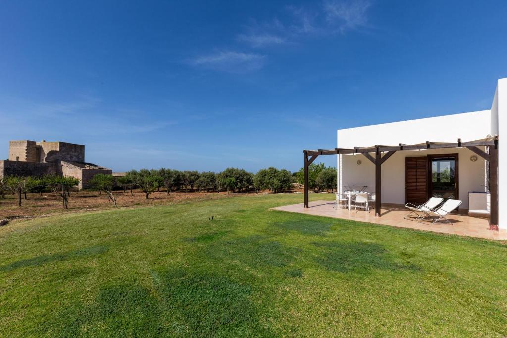 a house with a large yard next to a building at Le Casette a Favignana in Favignana