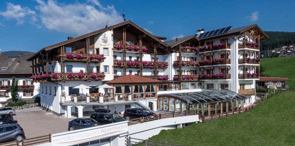 a large white building with flowers on the balconies at Hotel Alpenfrieden in Maranza