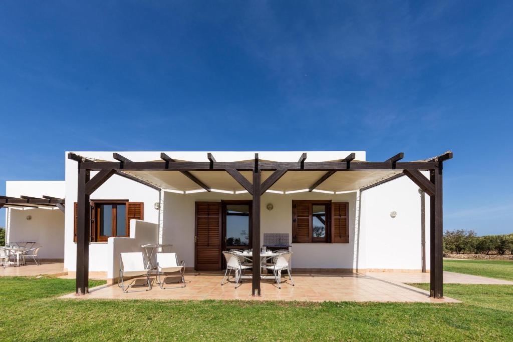 a pergola with a table and chairs on a patio at Le Casette a Favignana in Favignana