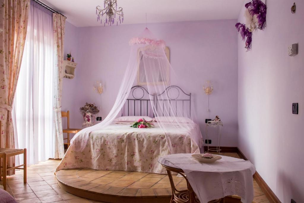 1 dormitorio con cama con dosel y mesa en sapori di bea, en Abbateggio